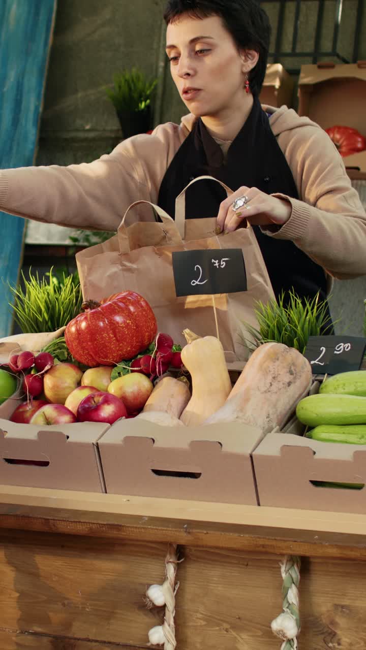Vídeo vertical: una joven huele unas manzanas y compra en un mercado de agricultores