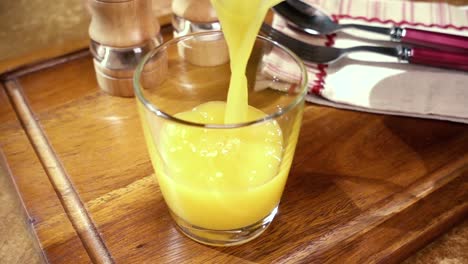 Orangensaft-In-Ein-Glas-Gießen,-Das-Morgendliche-Frühstück.-Zeitlupe-Mit-Rotierender-Kamerafahrt.