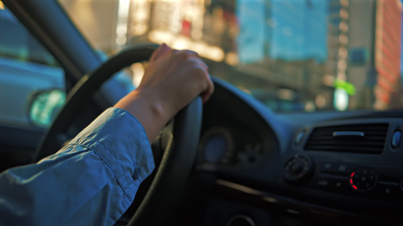 Woman driving the car in the city traffic, in daylight