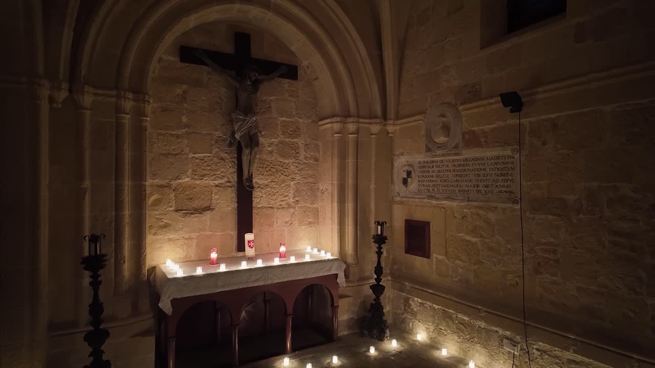Serene candlelit altar with a crucifix and historic inscriptions in one of the chapels of Fort St Angelo in Birgu, Malta