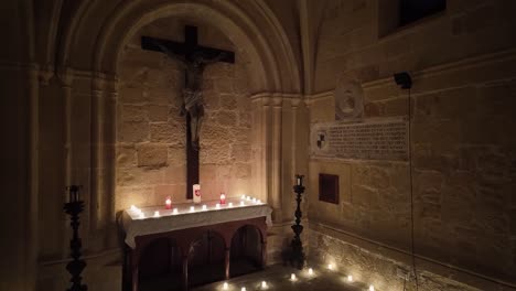 serene candlelit altar with a crucifix and historic inscriptions in one of the chapels of fort st angelo in birgu, malta
