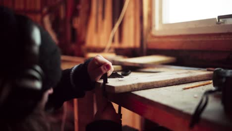 man with sanding stick tool making curves at panel board plank over table