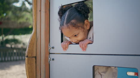 girl enjoy game playground looking from window toy house close up.