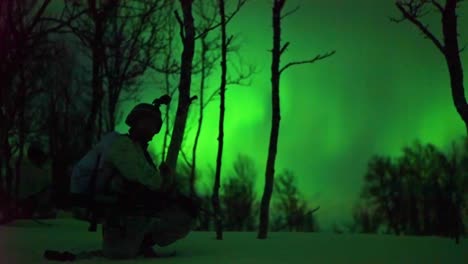 norwegian army soldiers exercise ground tactics at night with the northern lights in background 1