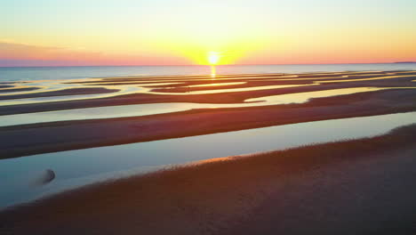 aerial view of a beautiful sunset over a beach with sandbars and people
