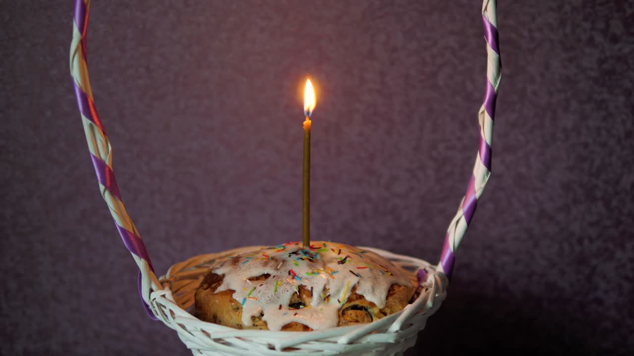 pastel de pascua festivo con una vela ardiente en una canasta de mimbre