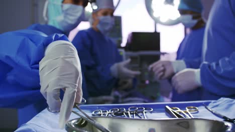 Multi-ethnic-surgeons-performing-surgery-in-operation-room-at-hospital