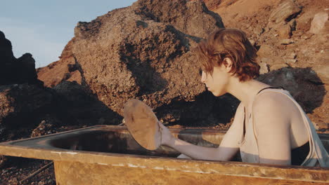 woman sitting in bath and looking in mirror in post apocalyptic world