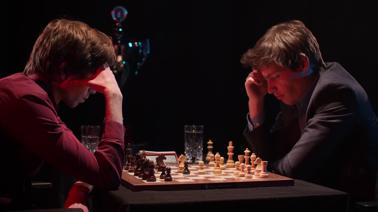 Two men locked in intense ranked chess match plan their next moves in timed tournament