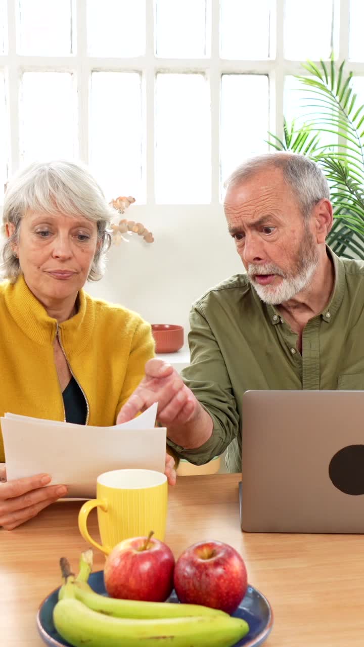 Coppia di anziani che discute di finanze a casa