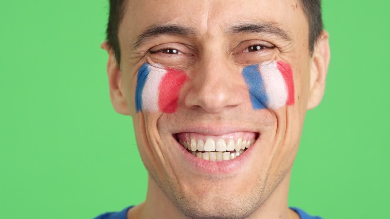 Man with a french flag painted on the face smiling