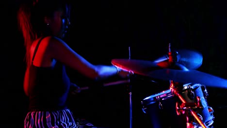 batería femenina tocando en un conjunto de tambores 4k
