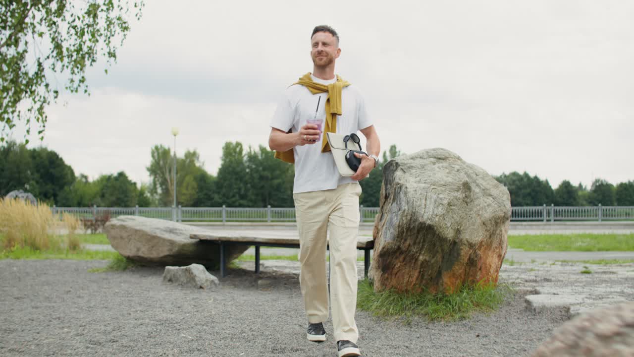 Uomo al parco con laptop e bevanda
