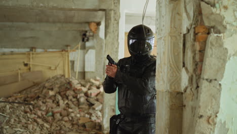 Motociclista-Con-Pistola-Se-Esconde-Detrás-De-La-Pared-En-Un-Edificio-Antiguo