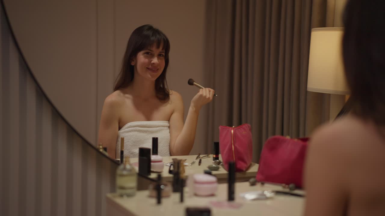 mujer aplicando maquillaje frente al espejo