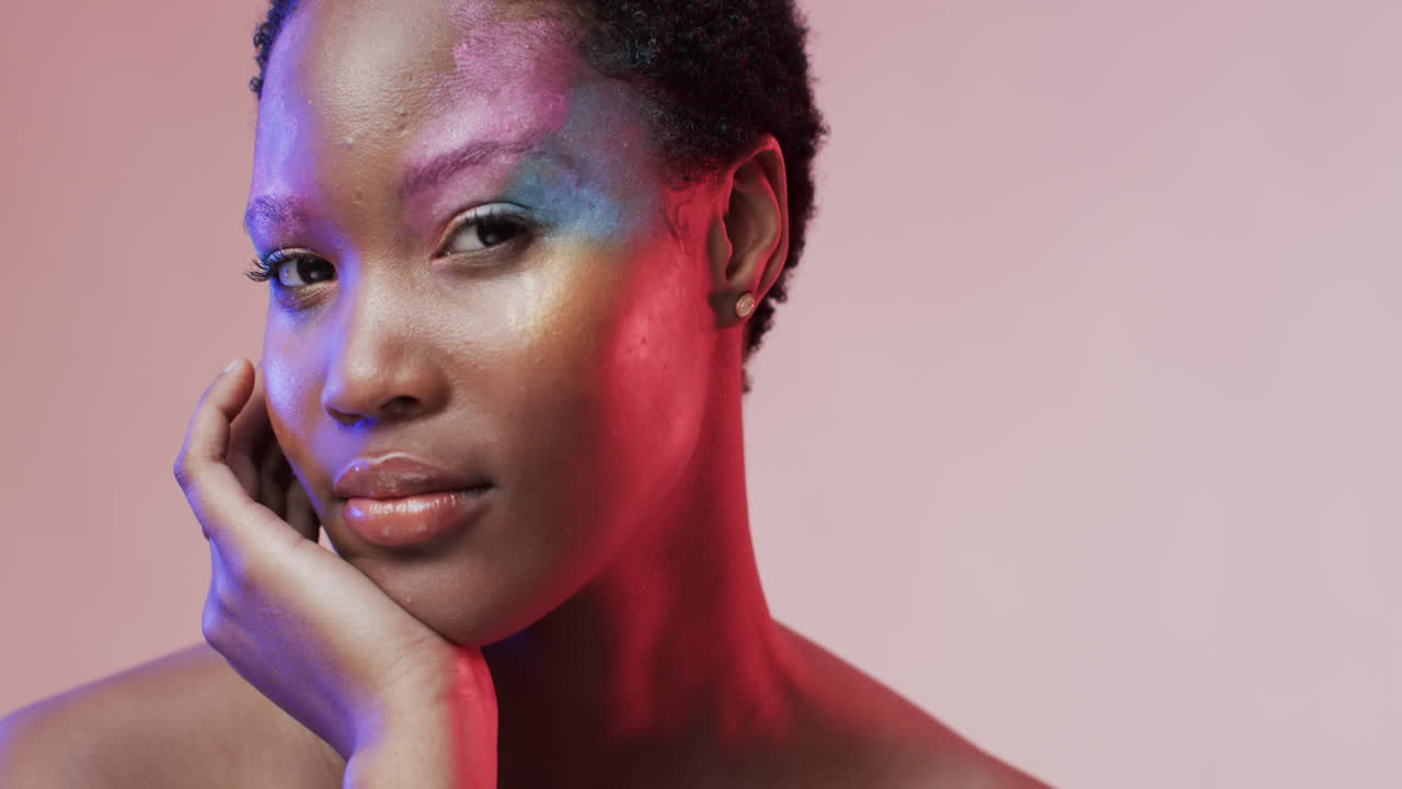 African american woman with short dark hair in blue and pink light with copy space, slow motion