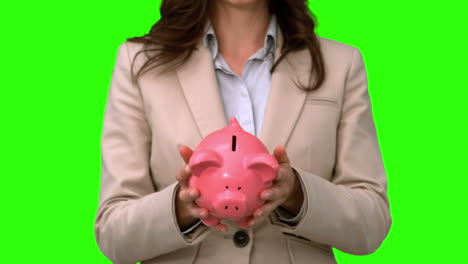 businesswoman throwing a piggy bank on green screen