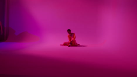 camera moves through studio equipment to show female kathak dancer wearing traditional indian dress preparing for performance