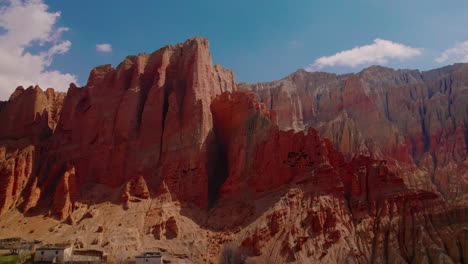 experience the allure of dhakmar village in upper mustang, nepal. drone glides around a unique structured cliff, capturing the artistic stone backdrop. discover the beauty of annapurna area gem