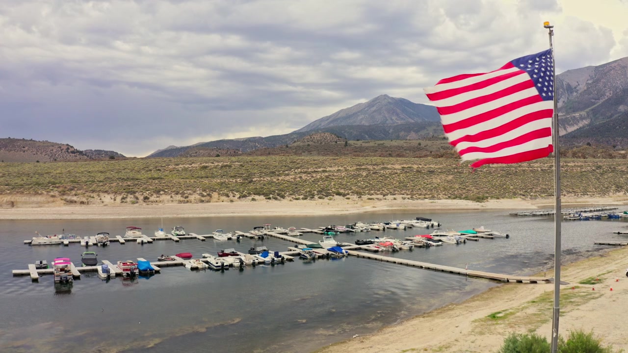 Rekaman Drone Menunjukkan Danau Crowley serta Dek Perahu Nelayan dan Bendera Amerika Serikat di Latar Depan