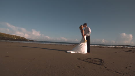 Atractiva-Pareja-Nupcial-Besándose-En-La-Playa