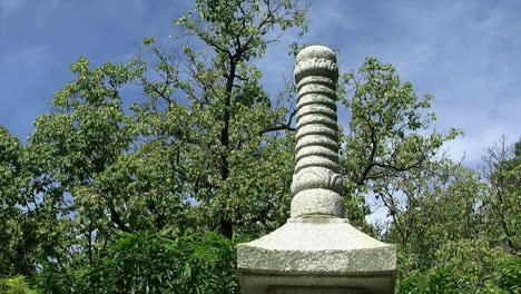 top of a stone pagoda against a background of trees and sky