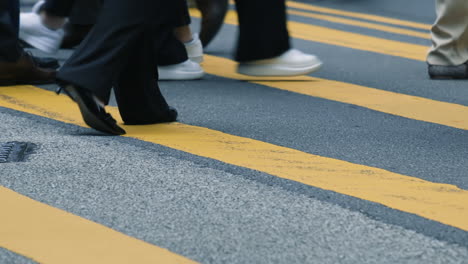 Close-up-of-people-feet-on-busy-crosswalk