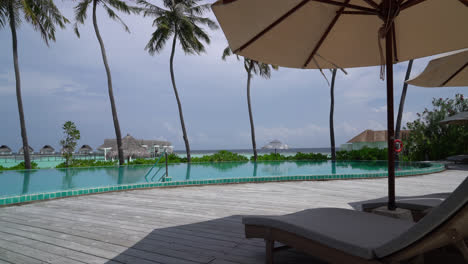 beach chair around swimming pool with sea background