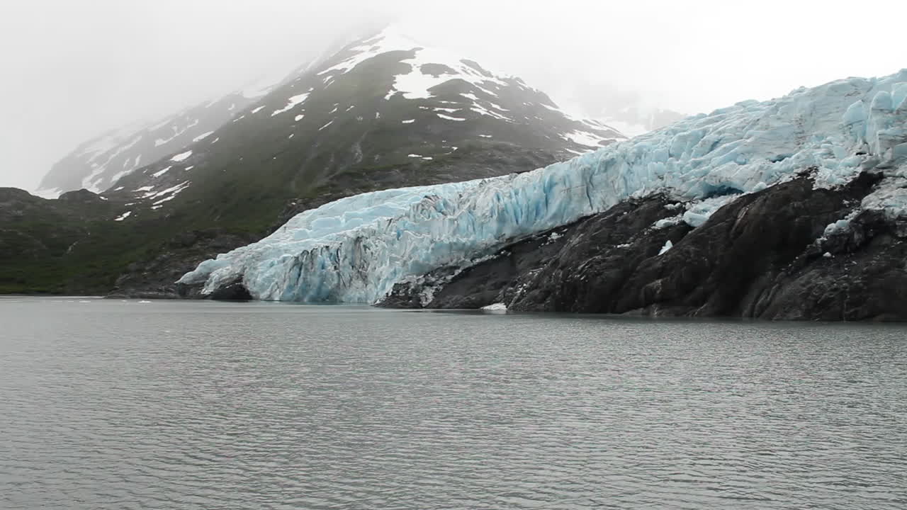 Floating by on a boat near the Seward Glacier with a small mountain in the background