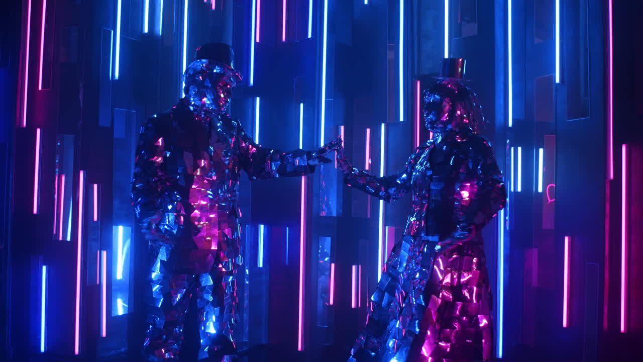 거울로 된 의상을 입은 재미있는 춤추는 커플이 루프 동작을 합니다.