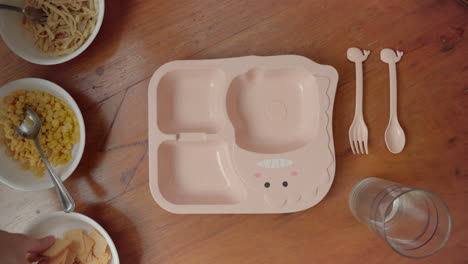 persona poniendo galletas en un plato dividido para niños - preparando y emplatando comida para niños