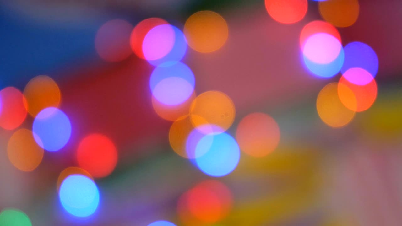 Blurred colorful lights. Red, green, yellow, orange, blue defocused glittering bokeh festive background.