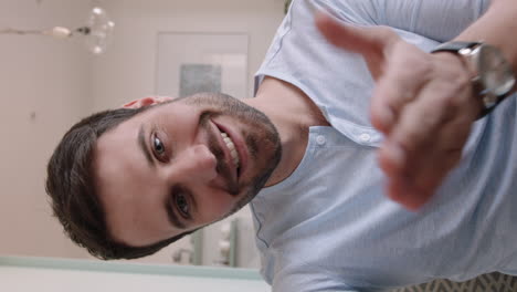 hombre joven atractivo teniendo video chat usando lenguaje de señas en el teléfono inteligente charlando compartiendo estilo de vida disfrutando de la comunicación en línea en casa en pantalla vertical