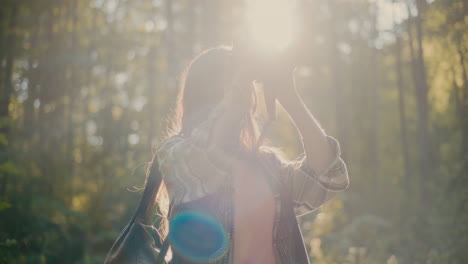 wanderer schaut durch ein fernglas im wald