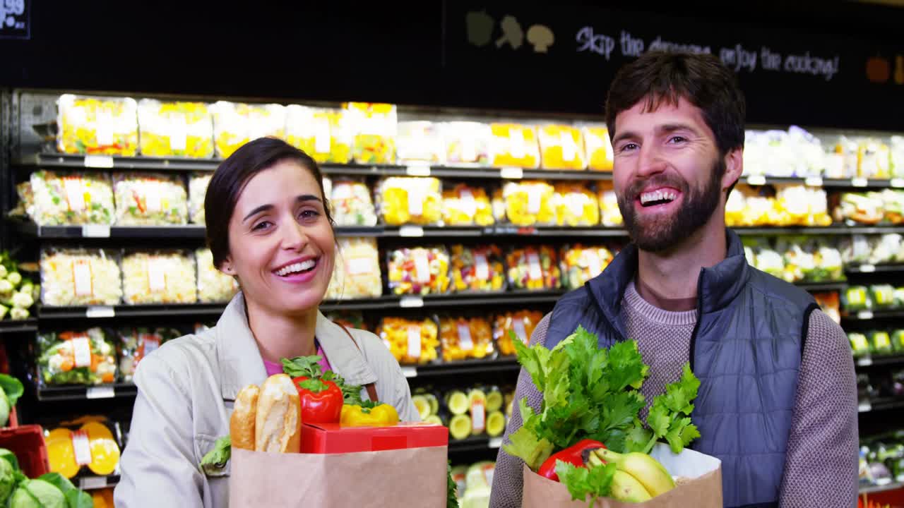 pareja comprando frutas y verduras en la sección orgánica