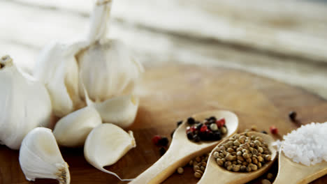 garlic bulbs and spices on wooden board 4k