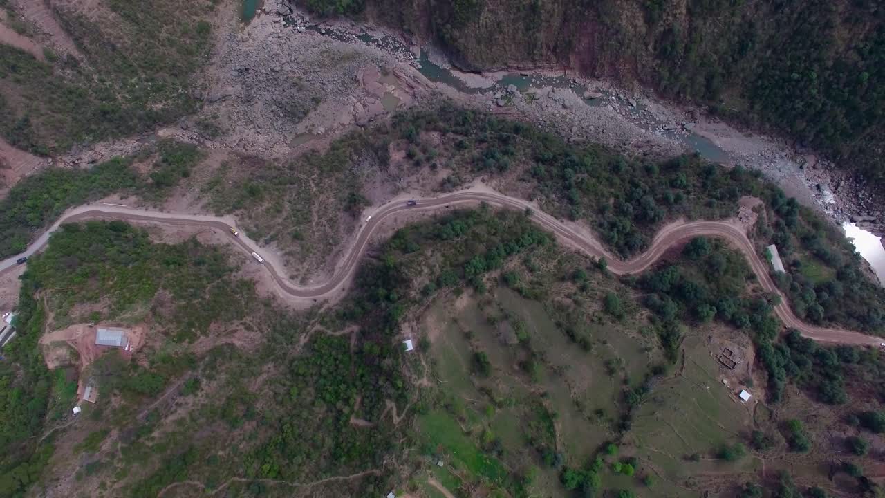 un camino accidentado entre las montañas y un río fluye