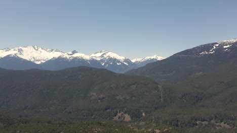 Drone-footage-of-the-distant-snowy-mountains-at-Squamish-in-BC,-Canada