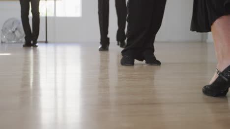 mixed race male dance teacher taking a ballroom dancing class at a dance studio