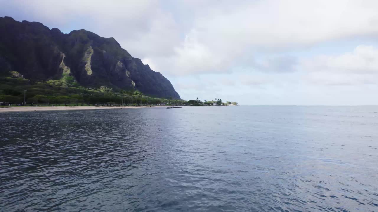 Una vista aerea mozzafiato della costa di Oahu con lussureggianti montagne verdi che incontrano l'oceano tranquillo.