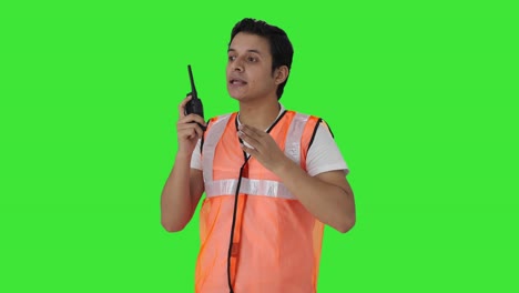 Trabajador-Del-Aeropuerto-Indio-Dando-Instrucciones-En-La-Pantalla-Verde-De-Walkie-Talkie