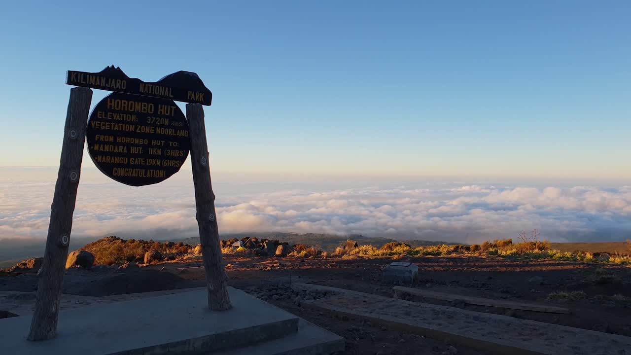 vista desde el letrero de la cabaña de horombo al atardecer por encima de las colinas en kilimanjaro