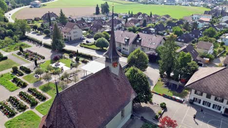 Drone-flight-with-a-DJI-drone-at-low-level-over-the-beautiful-reformed-church-from-1664-in-Bätterkinden-and-the-cemetery-near-Bern-in-Switzerland