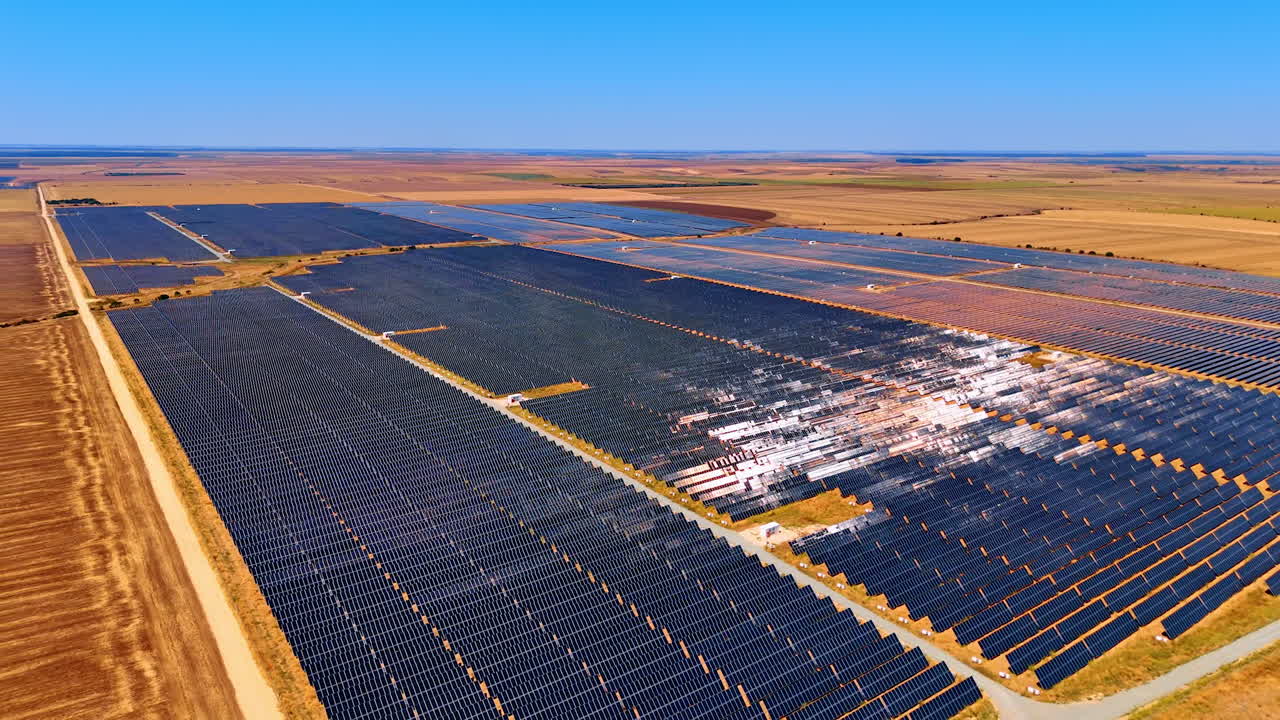 Large rural solar farm. A vast solar farm under a clear sky features rows of panels harnessing sunlight