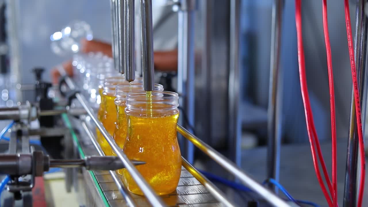 녹색 차 병은 컨베이어 벨트 시스템에서 전송됩니다. 녹색 차병은 공장에서 생산 포장 라인에서 수축 기계에서 이동합니다. 식품 및 음료에 대한 산업 개념