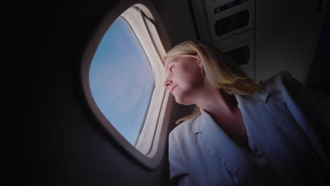 young caucasian woman traveling in an airplane looking out the window