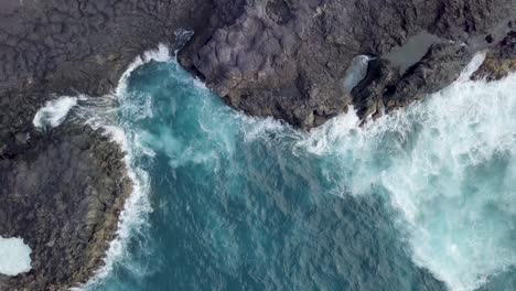 Luftaufnahme-Von-Wellen,-Die-In-Eine-Natürliche-Felsformation-Am-Strand-Krachen