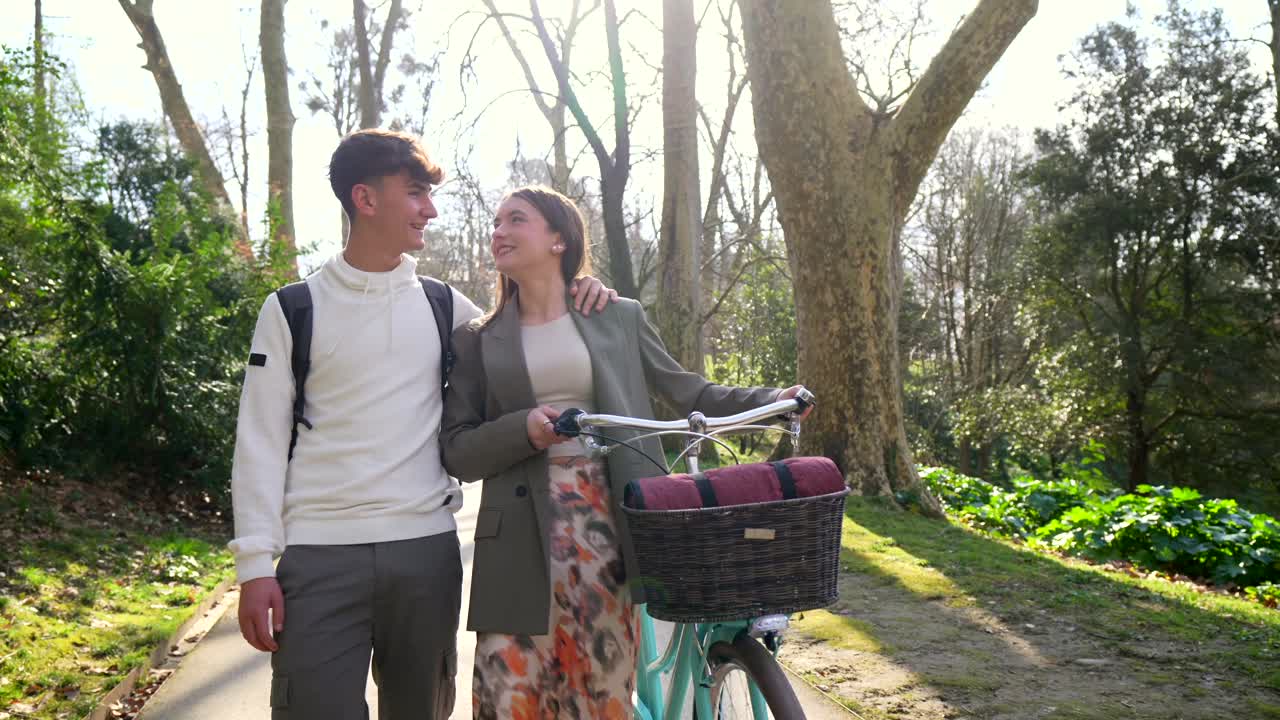 Couple walking with a bicycle in a park