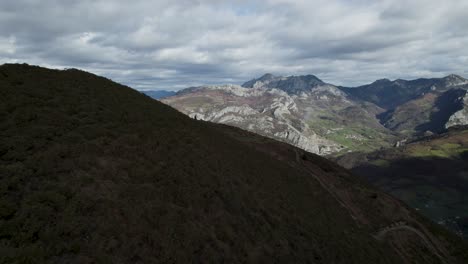 Dando-Marcha-Atrás-Alrededor-De-Una-Cresta-Con-Vistas-A-Un-Paisaje-Distante-Lleno-De-Picos-Montañosos