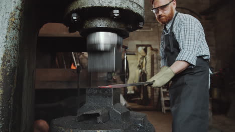 blacksmith working with power hammer